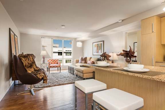 Open layout with living area and kitchen island at The Lyric Apartments, Seattle, WA