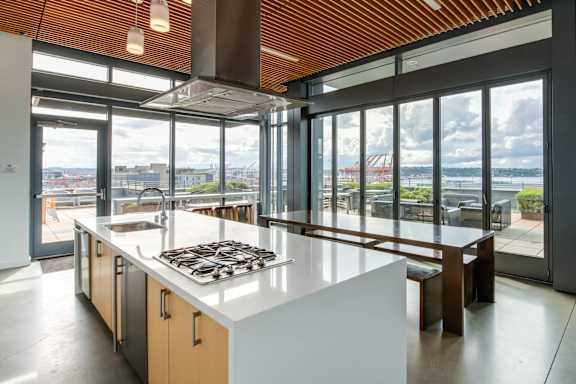 A modern kitchen with a large island and a view of the city.