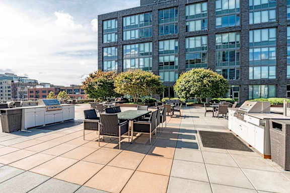 A patio with a table and chairs is in front of a large building.