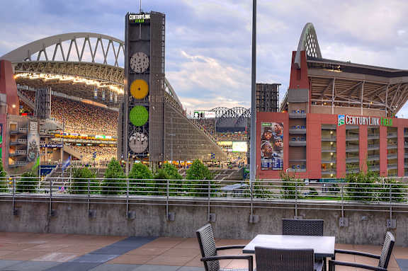 A clock tower is in the background of a stadium.