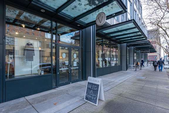 a sidewalk sign in front of a coffee shop on a city street