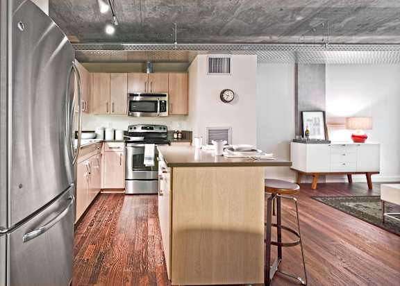 a kitchen with a island and a stainless steel refrigerator
