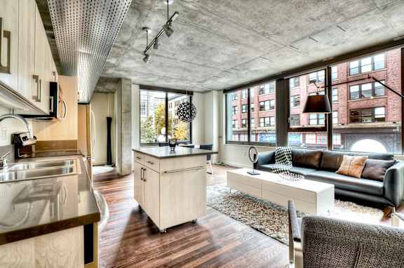 a living room with a kitchen and a large window