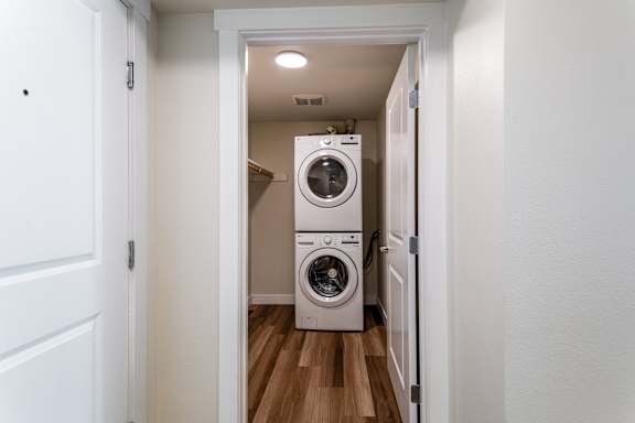 Stacked washer and dryer in closet laundry space at The Lyric Apartments, Seattle, Washington