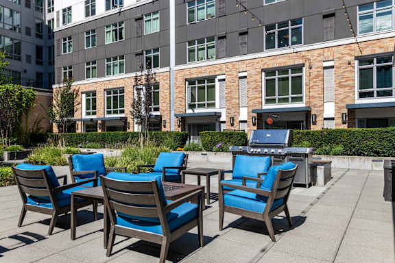 A patio with blue chairs and a table.