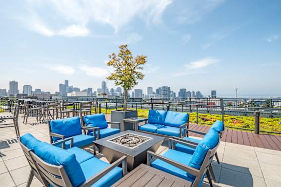 Rooftop lounge with fire pit and city skyline at The Lyric Apartments, Seattle