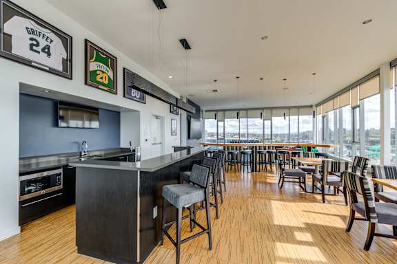 A modern bar with a wooden floor and a large window.