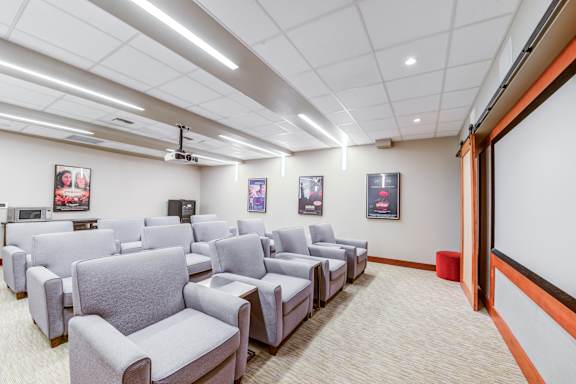 Theater room with projector and comfortable seating at The Lyric Apartments, Washington