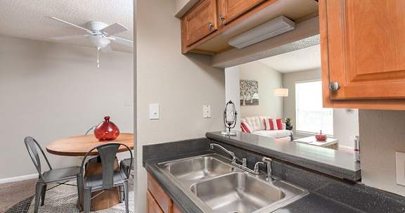 A kitchen with a table and chairs and a sink.