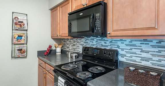 A kitchen with a black microwave above a black stove.