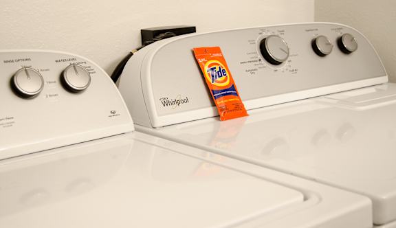 Washing ,machine with detergent powder on it at Hidden Lakes Apartments, Clarkston, MI, 48346