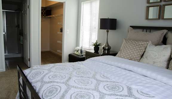Bedroom with a bed and nightstand at Pine Ridge Apartments, Michigan, 48307