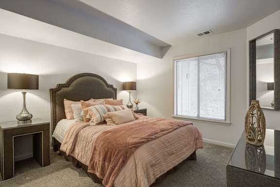 Bedroom with bed and nightstand at Hidden Lakes Apartments, Michigan