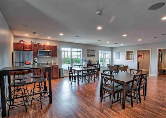 A large open-plan kitchen and dining room with dark wood floors and furniture.