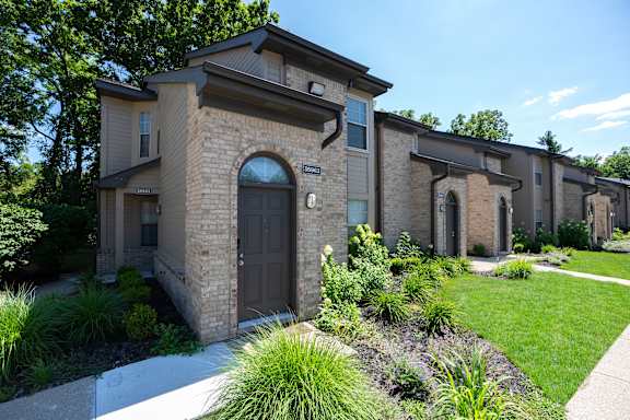 A row of houses with a green lawn in front.