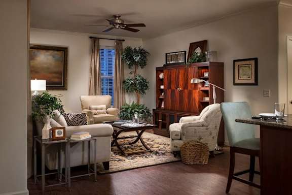 A living room with a white chair, a brown table, and a ceiling fan at Meridian West Shore, Pennsylvania 17055
