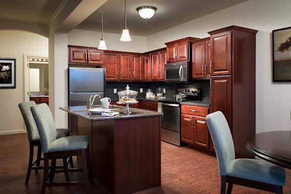 A kitchen with brown cabinets and a black refrigerator at Meridian West Shore, Pennsylvania