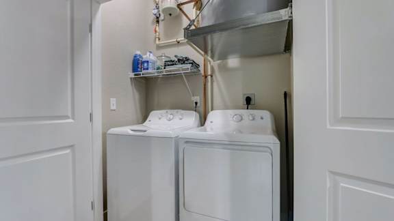 A white washing machine and dryer in a small laundry room.