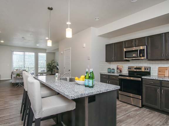 Kitchen island with pendant lighting and bar seating at Liberty Point Apartments, Utah, 84020