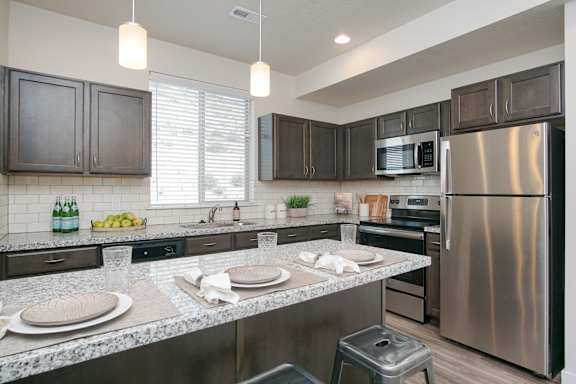 Contemporary kitchen with island seating and granite surfaces at Liberty Point Apartments, Draper, UT 84020