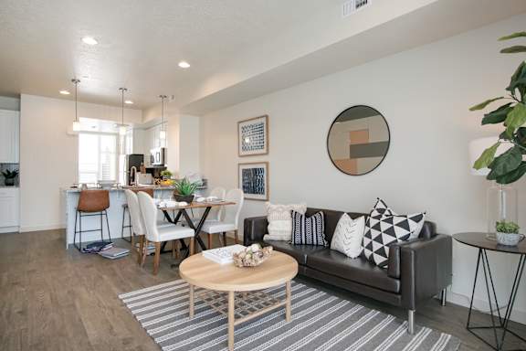 A modern living room with a brown couch and a wooden coffee table at Liberty Square Apartments - Saltlake City, UT Apartments, Apartments, Saltlake City, UT