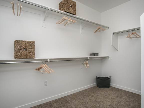 Walk-in closet with hanging rods and storage baskets at Liberty Point Apartments, Draper