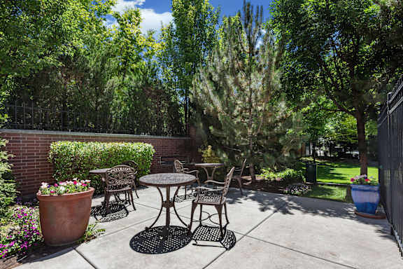 Patio seating area with shaded garden surroundings at Liberty Gateway Apartments, Utah, 84101