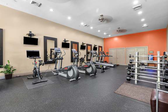 Fitness center with cardio machines and mirrors at Liberty Gateway Apartments, Utah