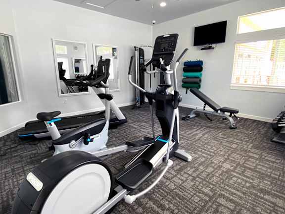 Fitness center with cardio equipment and weights at Liberty Hill Apartments, Draper, Utah