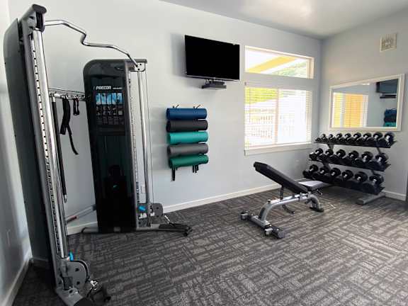 Fitness center with cable machine and dumbbells at Liberty Hill Apartments, Draper