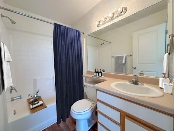 Bathroom with tub shower combo and navy curtain at Liberty Hill Apartments, Draper, UT 84020