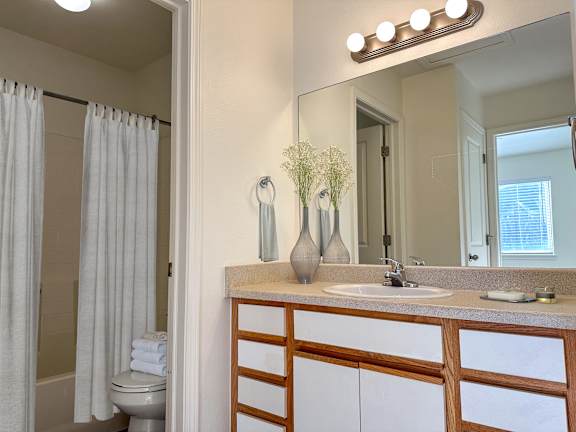 Bathroom with granite countertop and white shower curtain at Liberty Hill Apartments, Draper