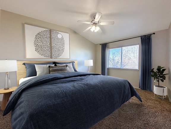 Master bedroom with navy bedding and ceiling fan at Liberty Hill Apartments, Utah