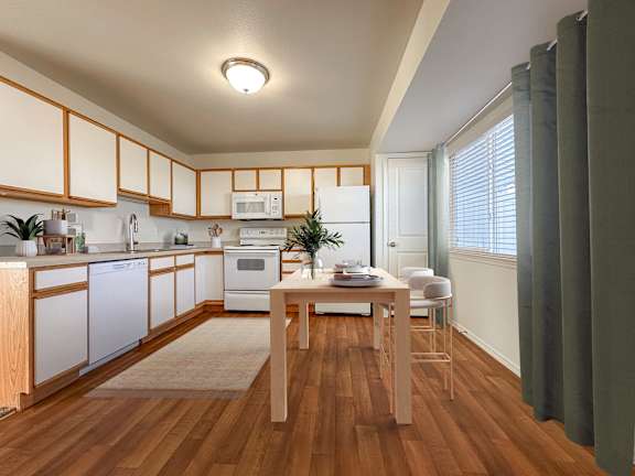 Modern kitchen with white appliances and dining table at Liberty Hill Apartments, Utah, 84020