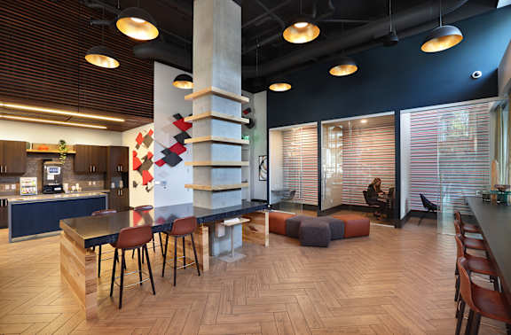 A modern dining area with wooden floors and a long table with chairs.