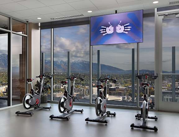 A gym with stationary bikes and a screen showing a pair of eyes.