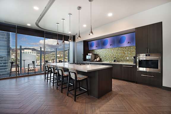 A modern kitchen with a bar area and a view of the city.