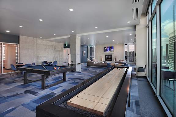 A room with a pool table and a shuffleboard table.
