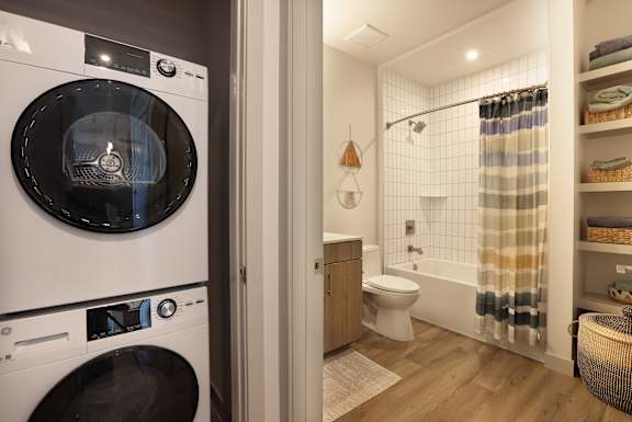 A modern bathroom with a washing machine built into the wall.