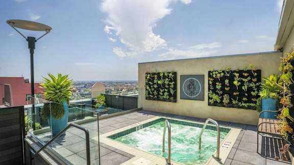 A small pool on a balcony with a view of the city.
