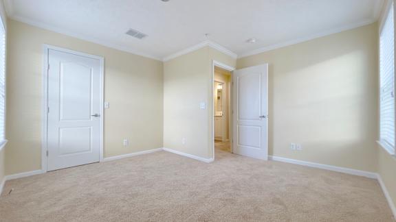 A room with beige carpet and white doors.