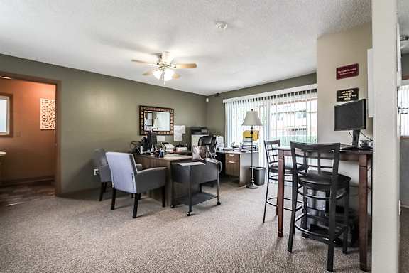 A room with a desk and chairs.