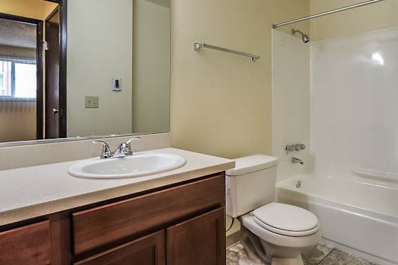A bathroom with a toilet, sink, and bathtub.