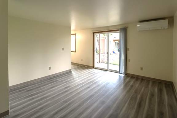 A room with a LVP floor and sliding glass doors.