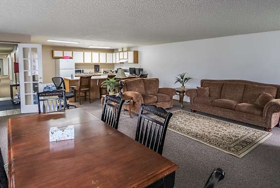 A living room with brown couches and a wooden table.
