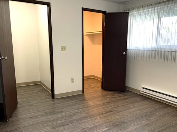 A room with a brown door and a white wall.
