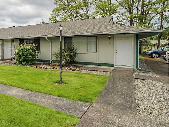 A small house with a green lawn in front.