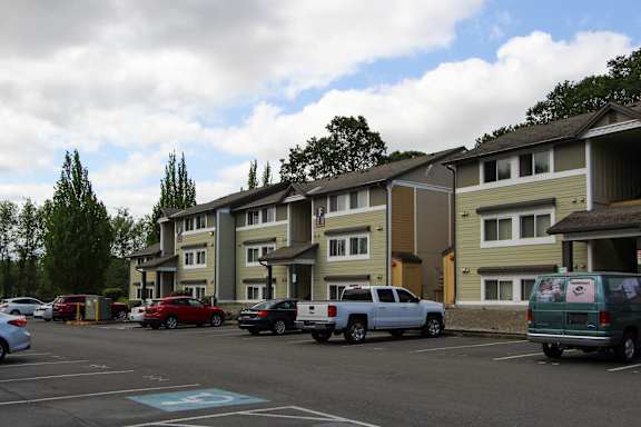 A parking lot with cars and a building in the background.
