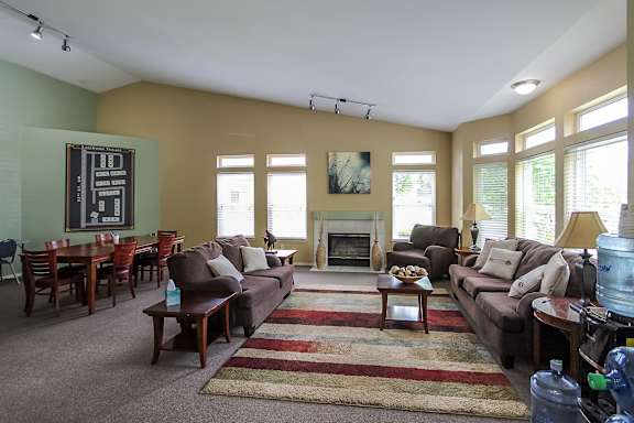 A living room with a fireplace and a painting on the wall.
