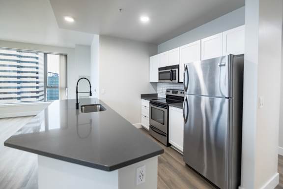 A modern kitchen with stainless steel appliances and a large island.